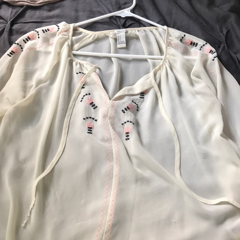 Cream blouse with pink and black embellishments